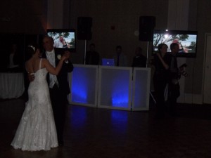 Amy and her father share a spotlight dance with photos of them playing in the background